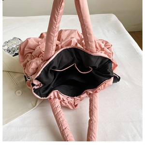 Détail intérieur d'un sac rose matelassé montrant la doublure et les rangements