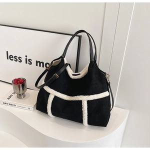 Detail of black suede tote bag with white fleece trim and sturdy leather handles