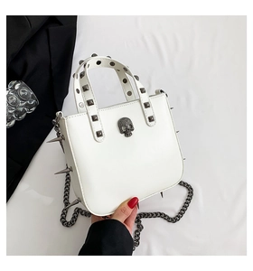 Detail of white leather punk bag with silver skull ornament and gothic metal studs
