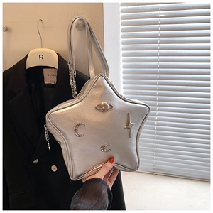 Detail of silver star-shaped handbag with metallic planet and moon relief decorations