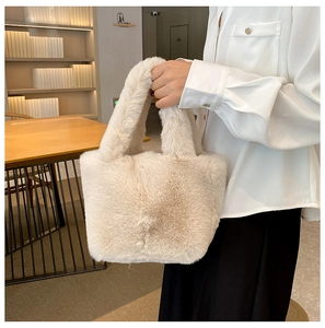 Detail view of the soft beige plush faux fur texture and sturdy handle on the bucket bag