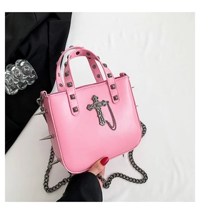 Detail of pink gothic punk handbag featuring metal cross and sharp side rivet studs