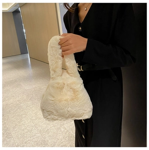 Detail of soft white faux fur handbag texture and integrated plush handle for winter