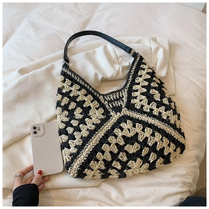 Detail of the woven checkered texture and leather strap on this large boho hobo bag
