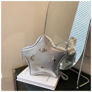 Detail of silver star-shaped handbag with metallic Saturn ornaments and chain strap