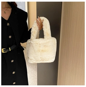 Detailed close-up of cream plush handbag with soft faux fur texture and dual handles