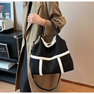 Detail of black suede tote with white faux shearling trim and adjustable strap
