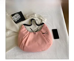 Bolso de hombro en nylon rosa con cordón y smartphone para referencia de tamaño real