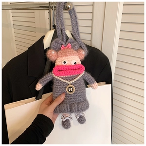 Détail d'un sac au crochet fait main gris avec lèvres roses et collier de perles