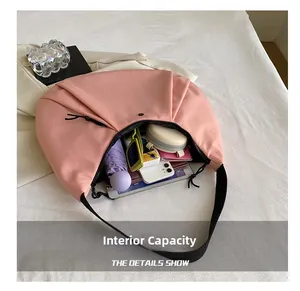 Interior del bolso media luna de nylon rosa mostrando gran capacidad para paraguas