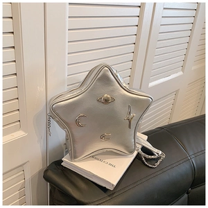 Detail of silver star-shaped crossbody bag with metallic moon and planet charms