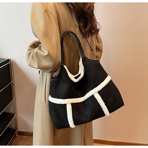 Detail of suede tote bag with white faux fur trim on a model in a warm indoor setting