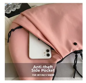 Detalle del bolsillo lateral antirrobo para smartphones en el bolso de nailon rosa