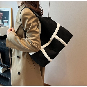 Detail of black suede tote bag with contrasting white shearling trim and large capacity
