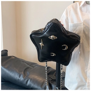 Close-up of black leather bag featuring cosmic metal charms and a star zipper pull