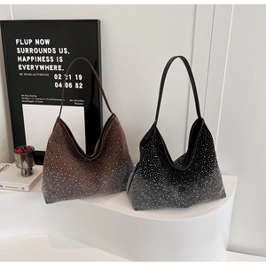 Détail des strass dégradés sur les sacs hobo marron et noir posés sur des supports blancs