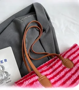 Détail du sac fourre-tout en peluche à rayures rouges et roses avec poignées en cuir marron