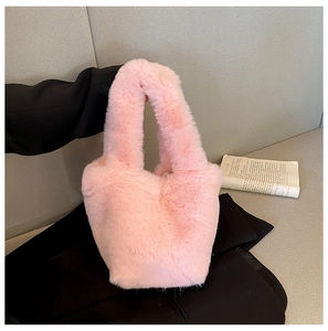 Close-up of pink faux fur plush handbag with a thick handle on minimalist background