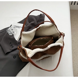 Detail view of large brown suede tote bag with warm white sherpa lining and inner pouch