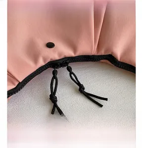 Vista de detalle del bolso de nailon rosa con cremalleras negras y cordones tejidos fuertes