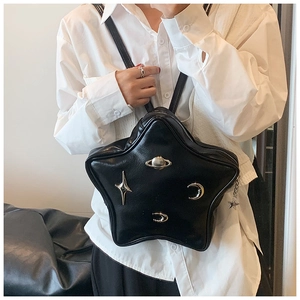 Detail view of a black star-shaped leather crossbody bag with silver metallic charms
