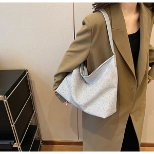 Détail du sac hobo argenté avec strass brillants et bandoulière en cuir pour femme