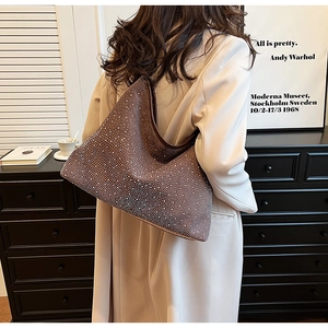Elegante borsa hobo marrone con strass argento mostrata in un ambiente d'arte vintage