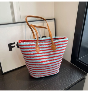 Détail du sac cabas en laine d'agneau à rayures rouges et bleues avec anses en cuir