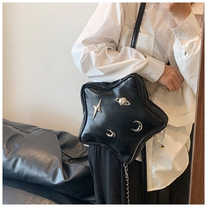 Macro detail of star-shaped black leather bag with silver planetary and crescent moon charms