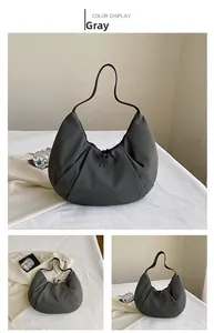 Detalle del bolso media luna de nylon gris mostrando cordón y correa de hombro