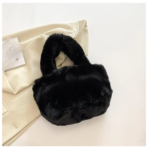Close-up of fluffy black faux fur handbag with a soft plush texture and round handle
