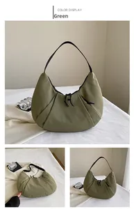 Detalle del bolso de hombro de nailon verde oliva con diseño plisado y cordón ajustable