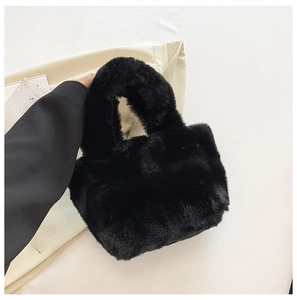 Detailed view of the soft black faux fur texture and handle of the plush bucket handbag