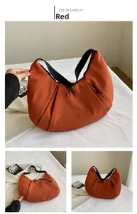 Detalle de bolso de hombro creciente rojo en nailon con correa negra y cordón con nudo