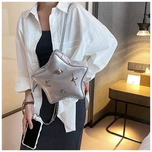 Close-up of star-shaped silver metallic bag featuring celestial Saturn and moon embossed details
