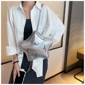 Close-up of silver star-shaped crossbody bag with metallic Saturn and moon charms