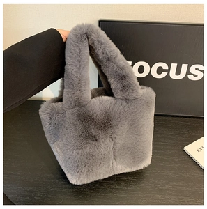 Detail of grey faux fur bucket handbag with soft texture and integrated handle design