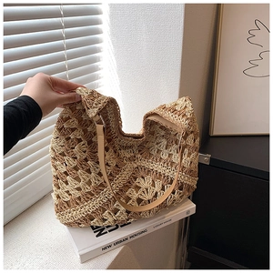 Detailed texture of hand-woven hollow floral pattern on a beige straw hobo bag