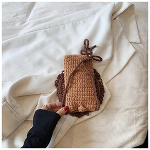 Détail d'un sac de téléphone marron tricoté à la main avec bordure en crochet