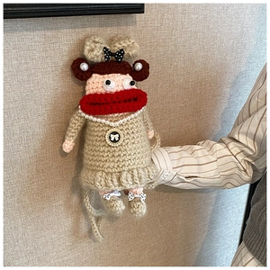 Détail du sac bandoulière fait main au crochet avec visage amusant et accessoires en perles