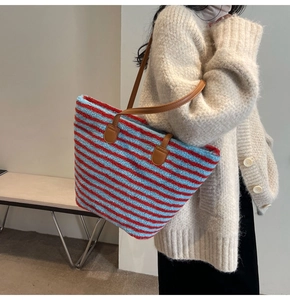 Détail du grand sac cabas en peluche rayé rouge et bleu avec bandoulières en similicuir