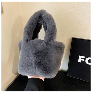 Detail showing the thick faux fur texture and integrated handle of the grey plush tote bag