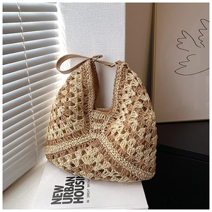 Close-up of beige crochet straw tote bag showing geometric texture and leather strap