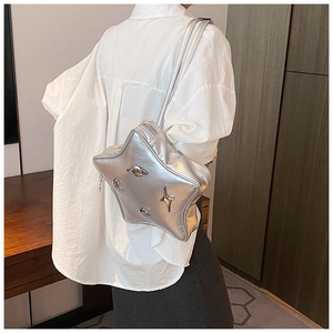 Close-up of star-shaped silver shoulder bag with metallic moon and planet details