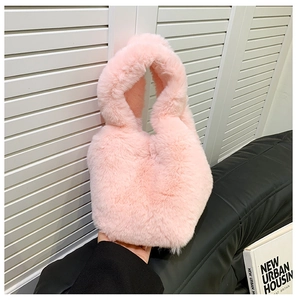 Close-up of pink fluffy faux fur bucket bag with a soft plush texture for autumn winter