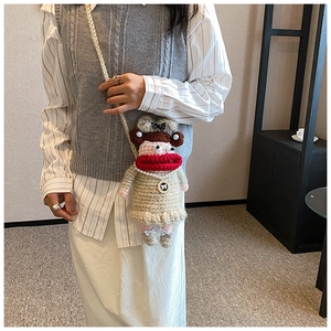 Détail du sac à bandoulière au crochet fait main avec un personnage aux lèvres rouges