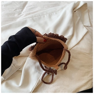 Détail montrant l'espace intérieur et la texture d'un sac bandoulière lion en tricot