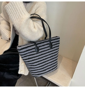 Gros plan sur le sac fourre-tout rayé en peluche avec anses noires en cuir