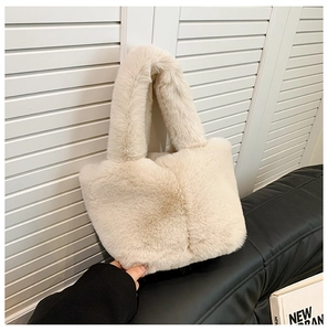 Detail of soft cream faux fur tote bag with plush wide handle and fluffy texture