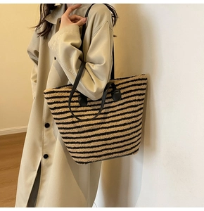 Détail du sac cabas en polaire à rayures sur l'épaule avec trench-coat beige élégant